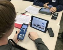 students using calculators and devices with Pivot Interactives on the screen