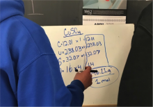 student working with group to create whiteboard